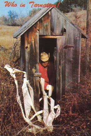 Guy in Outhouse looking oddly at reams of toilet paper